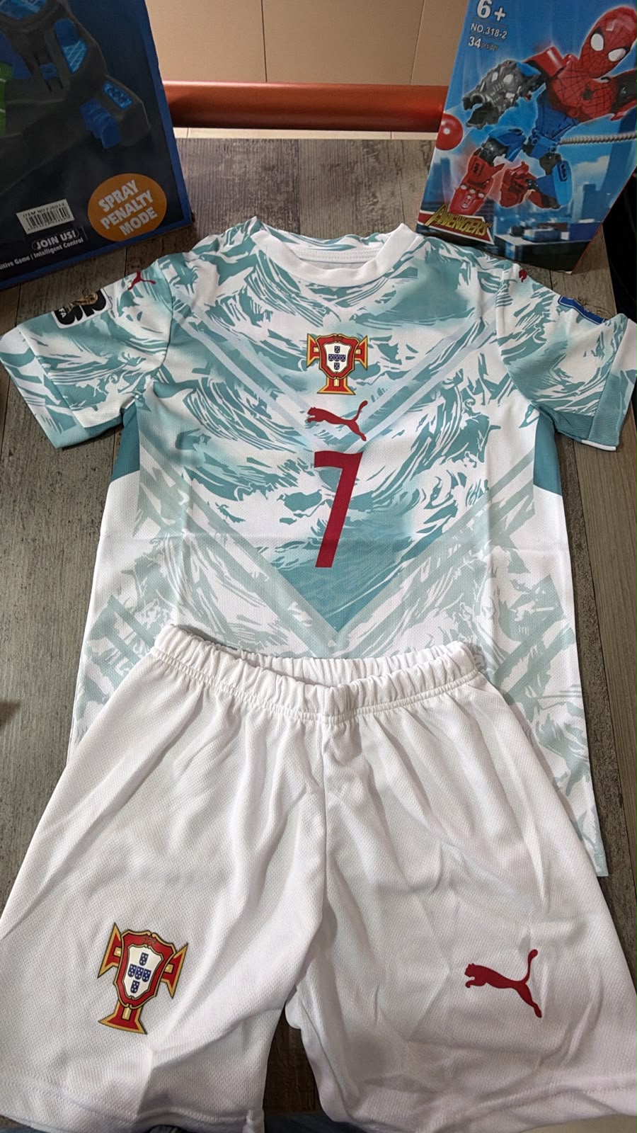 Portugal Puma away kids football kit number 7 Ronaldo white teal jersey and white shorts flat lay