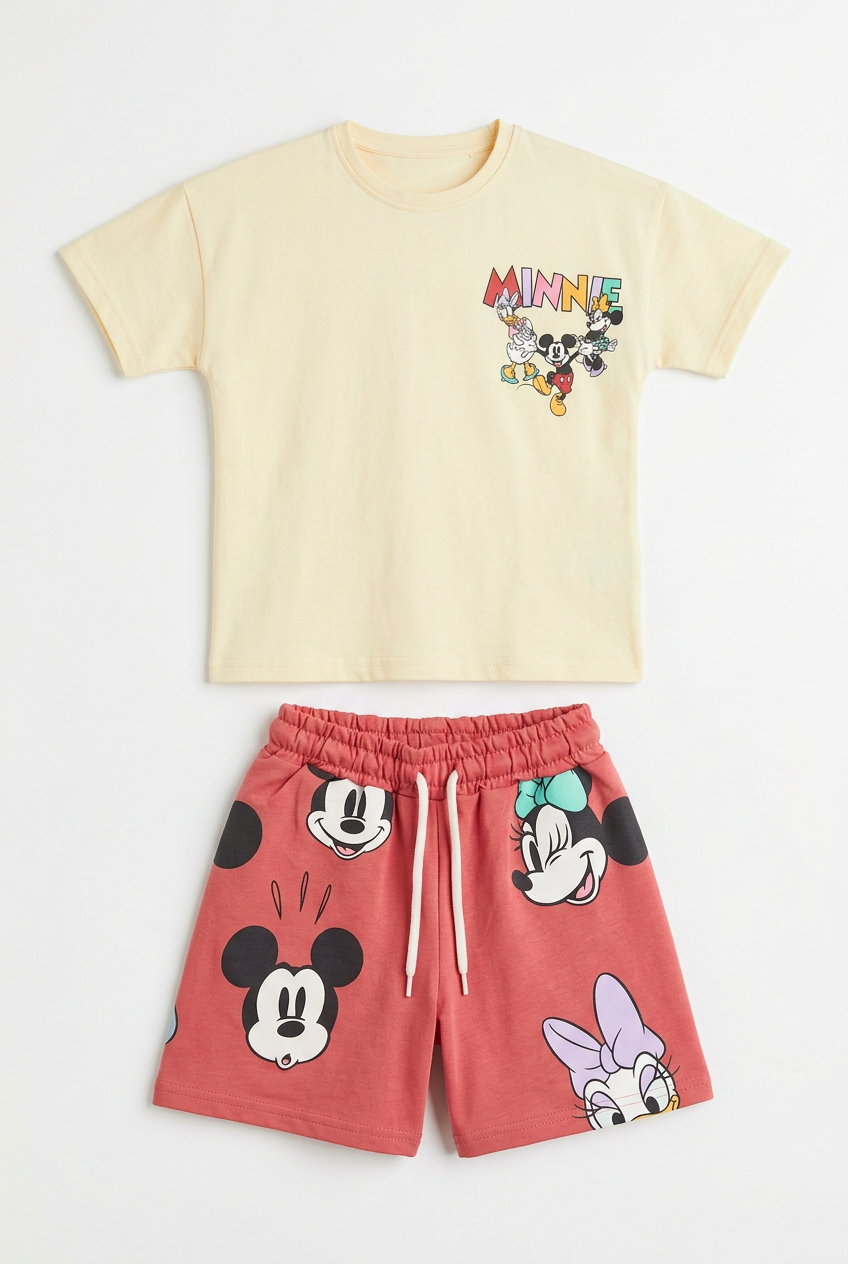 Yellow character top and red shorts set flat lay on white