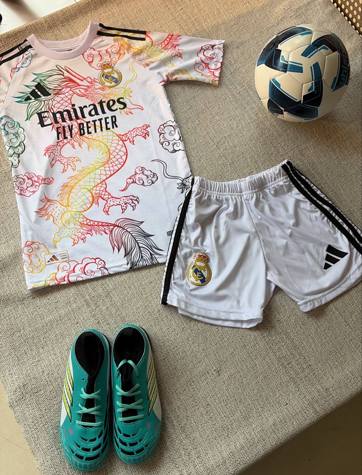 Real Madrid white dragon kids football kit colorful jersey and white shorts flat lay