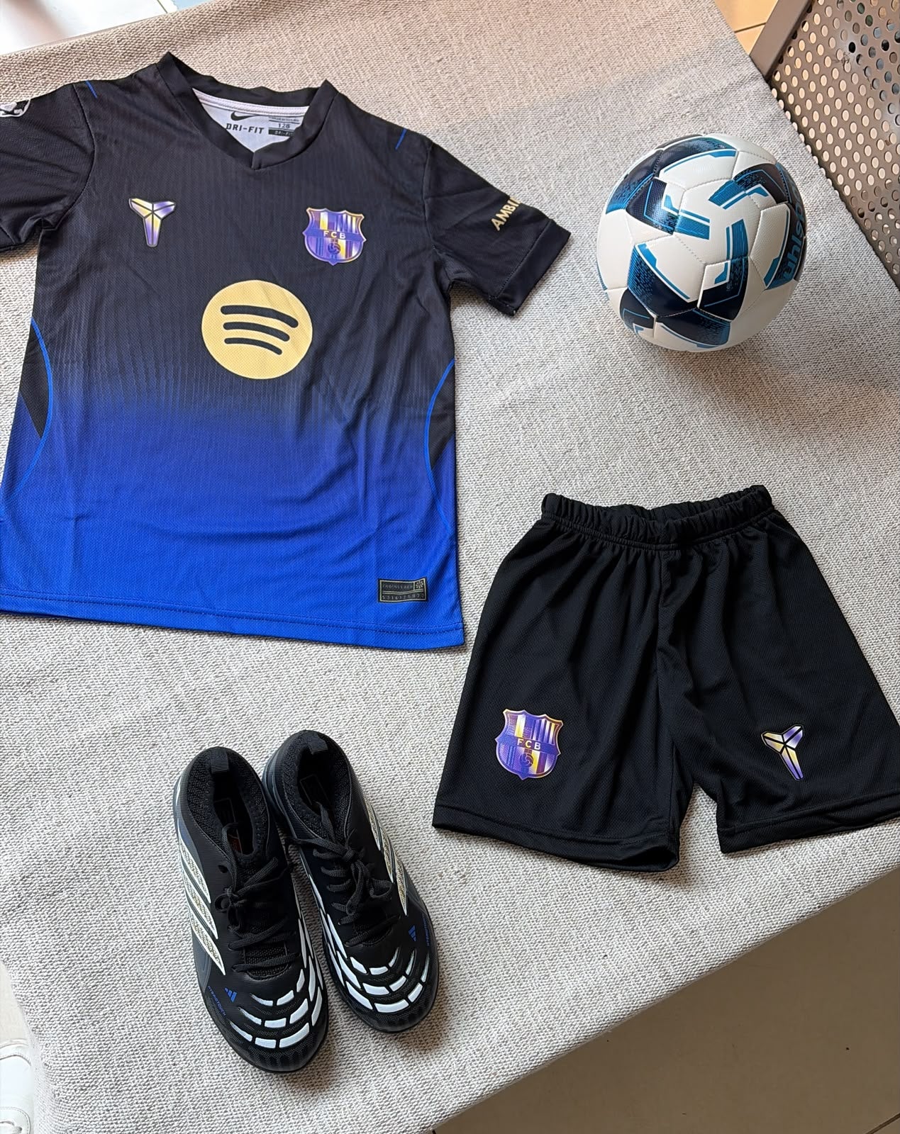 FC Barcelona x Kobe special edition kids football kit black blue gradient jersey Spotify sponsor and black shorts flat lay