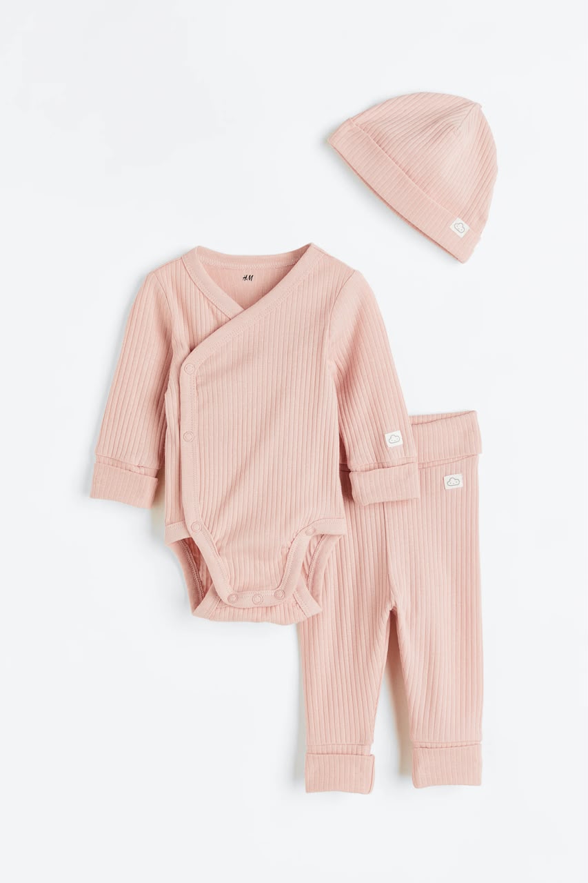 Pink ribbed baby set with wrap bodysuit, pants, and beanie