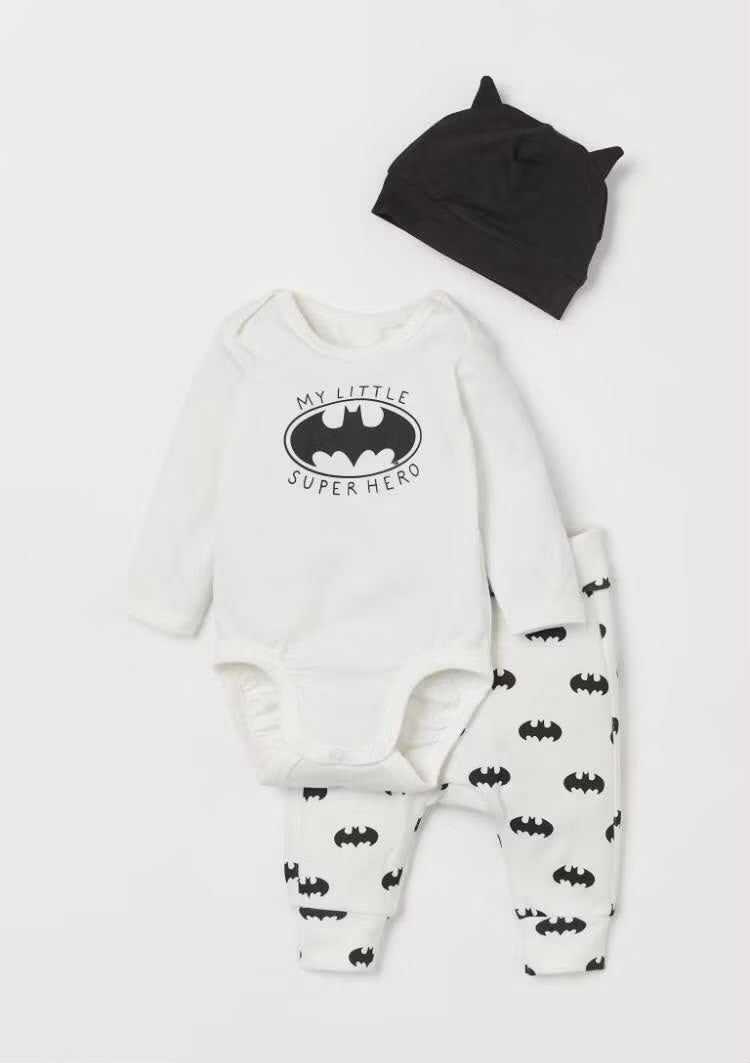 Black and white little superhero baby set with bodysuit, printed pants, and hat