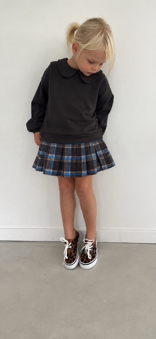 Girl wearing a charcoal Peter Pan collar sweatshirt and navy plaid pleated skirt