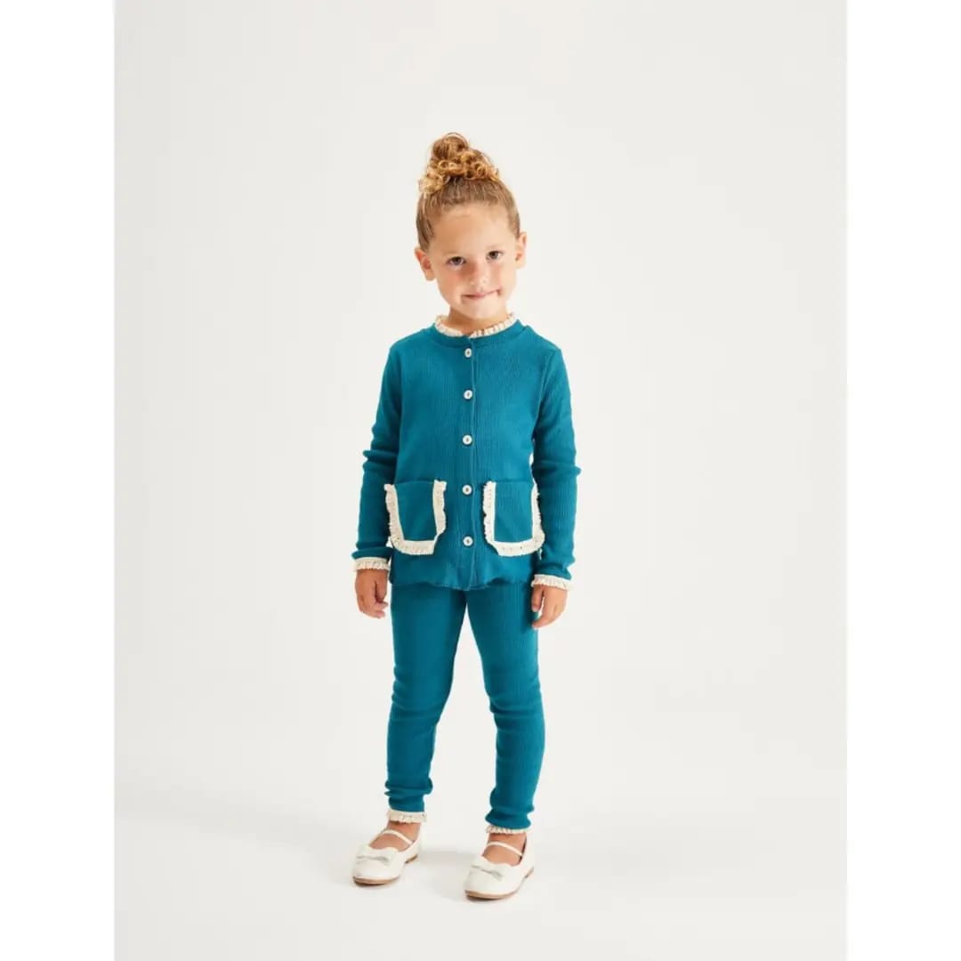 Girl wearing teal button-front top with cream-trimmed pockets and matching leggings