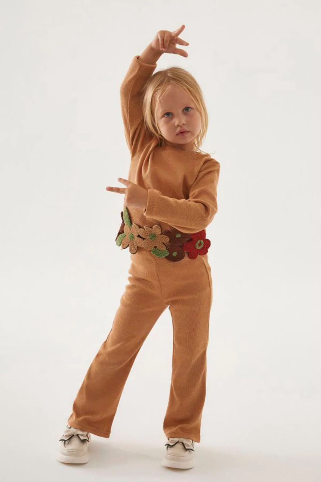 Girl wearing a caramel floral appliqué top and matching pants
