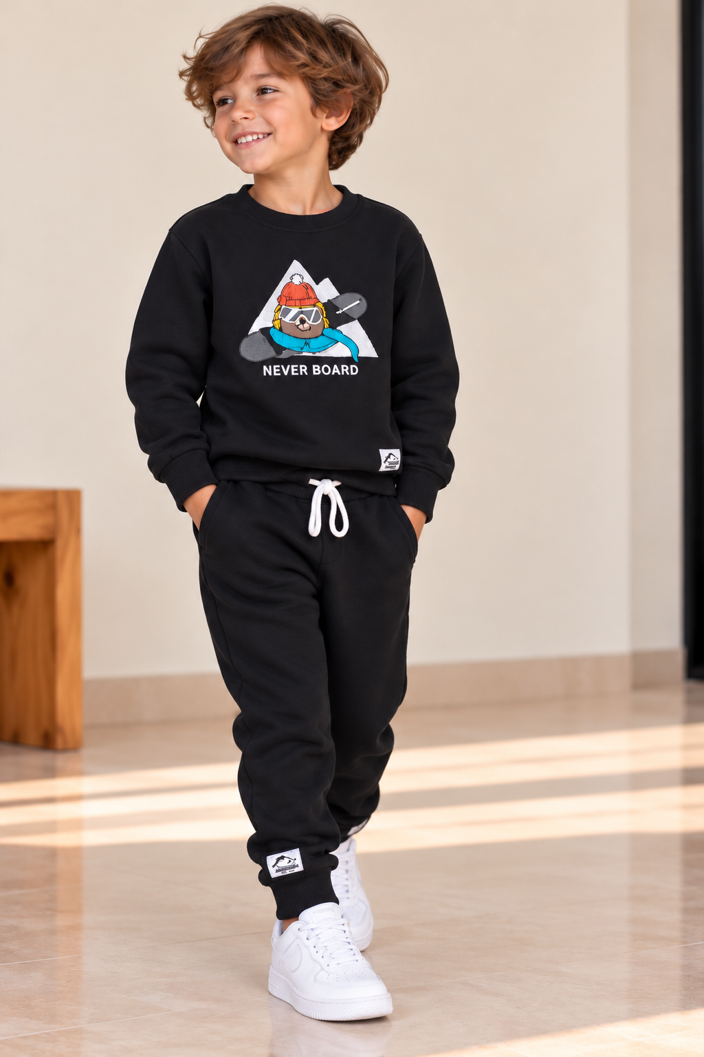 Boys’ black Never Board sweatshirt and matching black joggers with white drawstring
