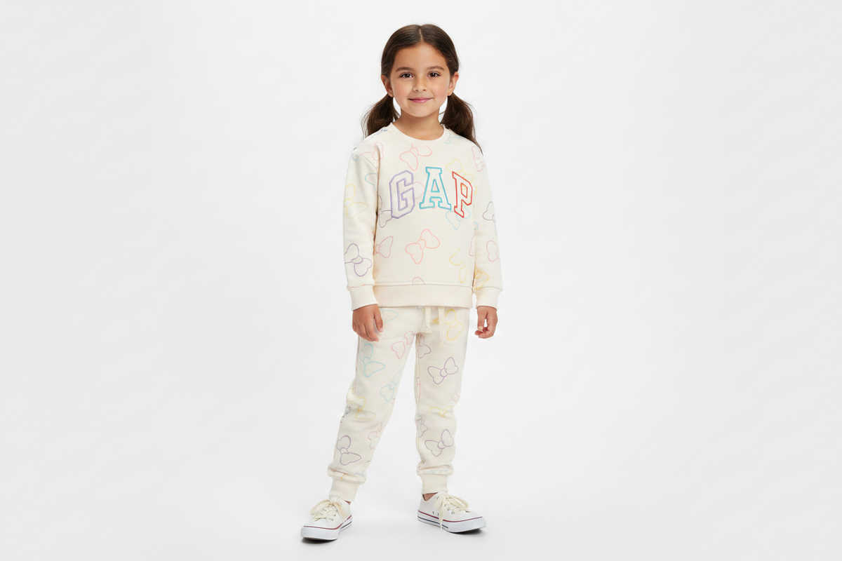 6 year old girl wearing cream GAP bow print pullover sweatshirt and matching joggers