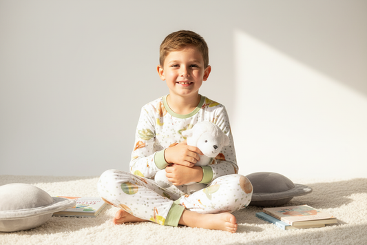 Boy wearing white space planets print pajama set with sage green trim