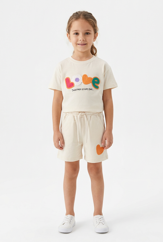 Girl wearing cream LOVE top and orange-heart shorts set