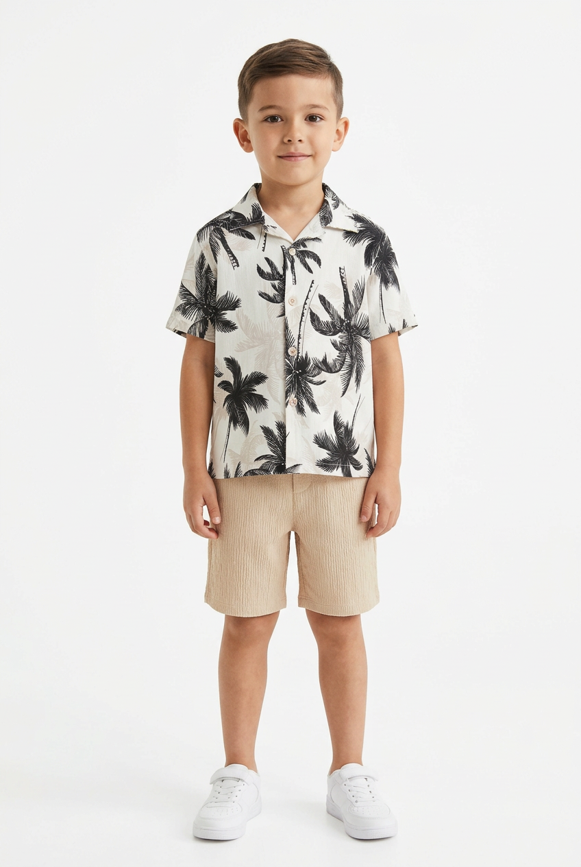 Boy wearing ivory palm-print shirt and textured beige shorts