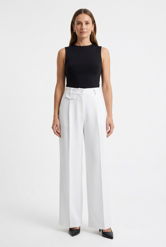 Model wearing white wide-leg trousers with a fitted black top and heels