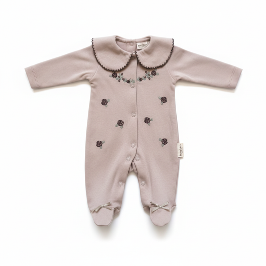 Dusty pink baby sleepsuit with peter pan collar and floral embroidery on white background